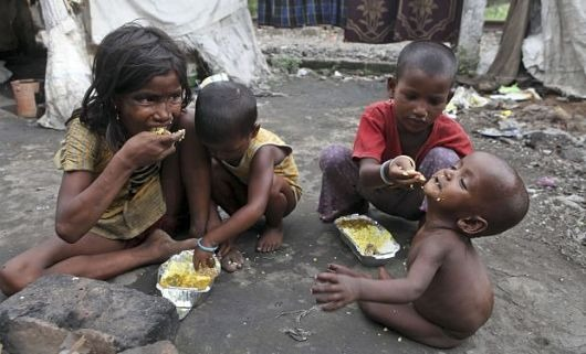 कचरे में बैठकर बच्चे खाना खाता हुए